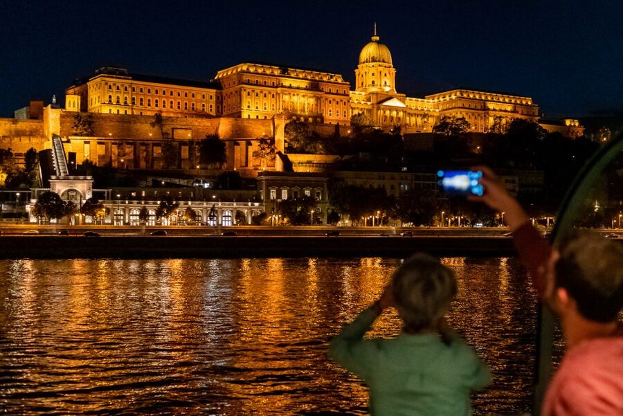 Buda Castle and the Chain Bridge lit above the Danube at night